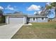 Well-maintained home with a two-car garage, a tidy lawn, and a clear, sunny sky above at 7399 Skylark Dr, Spring Hill, FL 34606