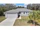 Charming single-story home featuring a well-manicured lawn, attached garage, and inviting curb appeal at 7399 Skylark Dr, Spring Hill, FL 34606