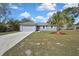 Single-story house has a two car garage, blue exterior paint, and a palm tree in the front yard at 7399 Skylark Dr, Spring Hill, FL 34606