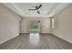 A spacious main bedroom with tray ceiling, ceiling fan, and sliding glass door to the outside at 7399 Skylark Dr, Spring Hill, FL 34606