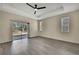 A spacious main bedroom with tray ceiling, ceiling fan, and sliding glass door to the outside at 7399 Skylark Dr, Spring Hill, FL 34606
