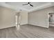 A spacious main bedroom with tray ceiling, ceiling fan, wood-look flooring, and ensuite bathroom at 7399 Skylark Dr, Spring Hill, FL 34606