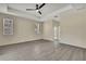 A spacious main bedroom with tray ceiling, ceiling fan, and wood-look flooring at 7399 Skylark Dr, Spring Hill, FL 34606