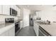 Updated kitchen with stainless steel appliances, granite countertops, and stylish white cabinets at 7552 Gardner St, Brooksville, FL 34613