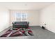 Bright living room features neutral walls and a gray tile floor with a modern gray couch at 7552 Gardner St, Brooksville, FL 34613