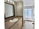 Bathroom featuring a vanity with light tan countertop and framed mirror, and enclosed shower area at 8055 River Country Dr, Weeki Wachee, FL 34607