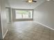 Spacious living room with tile flooring and ample natural light from a large window at 8055 River Country Dr, Weeki Wachee, FL 34607