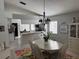 Bright dining room featuring white table, chairs, chandelier, open to the kitchen at 4733 Westerly Dr, New Port Richey, FL 34653