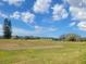 Picturesque view of the golf course, showcasing green fairways, mature trees and a pond at 3233 Teeside Dr, New Port Richey, FL 34655
