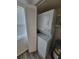 A laundry space featuring a stacked washer and dryer set adjacent to a shuttered storage cabinet at 3233 Teeside Dr, New Port Richey, FL 34655