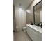 Bright bathroom with a large mirror, neutral-toned tiling, and a modern white vanity at 435 Mcdill Dr, Port Charlotte, FL 33953