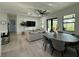 Open floor plan living room with ceiling fan, gray couches, and dining table at 435 Mcdill Dr, Port Charlotte, FL 33953