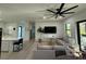 Bright living room featuring hardwood floors, modern ceiling fan, and comfortable gray sofas at 435 Mcdill Dr, Port Charlotte, FL 33953