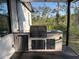 Outdoor kitchen with stainless steel grill, refrigerator, sink and gray countertop at 435 Mcdill Dr, Port Charlotte, FL 33953