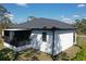 This is the rear exterior view showing a white one-story house with a screened-in porch at 435 Mcdill Dr, Port Charlotte, FL 33953
