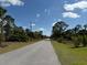 Quiet road surrounded by trees under a beautiful sky, showcasing the serene location at 435 Mcdill Dr, Port Charlotte, FL 33953