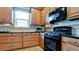 Well-lit kitchen features black appliances, wood cabinets, and granite countertops at 5352 Vaccaro Ct, Bradenton, FL 34211