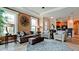 Well-lit living room featuring neutral tones, tray ceilings, comfortable seating, and large windows at 5352 Vaccaro Ct, Bradenton, FL 34211