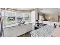 Modern kitchen with white cabinets and granite countertops at 1532 46Th Avenue E Dr, Ellenton, FL 34222