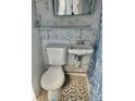 Small bathroom with toilet, sink, and nautical-themed walls at 3710 Gulf Of Mexico Dr # E3, Longboat Key, FL 34228