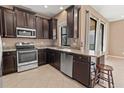 Modern kitchen with dark cabinetry, granite countertops, and stainless steel appliances at 7317 Skybird Rd # 7317, Bradenton, FL 34209