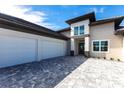 Three-car garage with paver driveway and dark trim at 5061 Collingswood Blvd, Port Charlotte, FL 33948