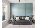 Living room featuring a leather couch and a teal accent wall at 11926 Seabrook Ave, Lakewood Ranch, FL 34211