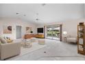 Living room with vaulted ceiling, neutral decor, and access to a patio at 1654 Waxwing Ct, Venice, FL 34293