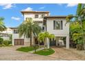 Beautiful modern home with a brick driveway, tropical landscaping, and covered parking at 5005 Gulf Of Mexico Dr # 5, Longboat Key, FL 34228