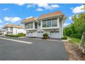 Two-story condo with attached garage and mature landscaping at 542 Sutton Pl, Longboat Key, FL 34228