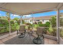 Relaxing screened porch with patio furniture, overlooking a garden at 542 Sutton Pl, Longboat Key, FL 34228