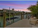 Private boat lift with dock and seating area at sunset at 4929 Oxford Dr, Sarasota, FL 34242