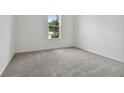 Well-lit bedroom with neutral carpeting and large window at 19642 Fort King Run, Brooksville, FL 34601