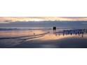 Couple walking on tranquil beach at sunset at 1305 4Th St # 201P, Sarasota, FL 34236