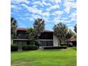 Two-story condo building with a red tile roof and palm trees at 3500 El Conquistador Pkwy # 142, Bradenton, FL 34210