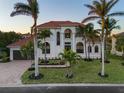 Stunning two-story home with tile roof, palm trees, and spacious driveway at 531 Ranger Ln, Longboat Key, FL 34228