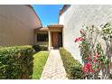 Inviting entryway with a brick pathway, lush landscaping, and a wooden door at 2383 Harbour Oaks Dr, Longboat Key, FL 34228