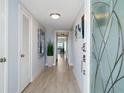 Bright condo entryway with light wood floors and glass door at 100 Sands Point Rd # 305, Longboat Key, FL 34228