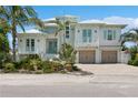 White two-story house with light teal accents, double garage, and lush landscaping at 149 Mckinley Dr, Sarasota, FL 34236