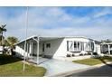 Front view of a white manufactured home with covered carport at 10 White Oak Ter, Sarasota, FL 34237