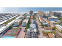 Aerial view of coastal community, tennis courts, pool, and ocean at 1150 Windsong Ln # 300, Sarasota, FL 34242