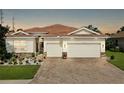 Beautiful home boasting a paver driveway, tile roof, stone accents, and a meticulously landscaped front yard at 1934 Mesic Hammock Way, Venice, FL 34292