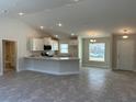 Open concept kitchen with white cabinets, granite countertops, and stainless steel appliances at 2738 N Chamberlain Blvd, North Port, FL 34286
