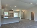 Open concept kitchen with island, white cabinets and gray flooring at 2738 N Chamberlain Blvd, North Port, FL 34286