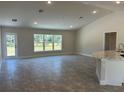 Spacious living room with large windows, gray tile floors, and access to the backyard at 2738 N Chamberlain Blvd, North Port, FL 34286