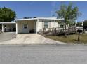 Front view of a manufactured home with a carport and ramp at 4906 Sea Island Ave, Sarasota, FL 34234