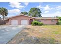 Pink single story home with a two car garage and a spacious yard at 358 Suwanee Ave, Sarasota, FL 34243