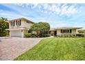 Two-story home with landscaped yard and brick driveway at 1701 Sandalwood Dr, Sarasota, FL 34231