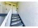 Staircase leading to multiple units featuring secure doors and classic white railings at 3607 E Bay Dr # 202, Holmes Beach, FL 34217