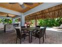 Outdoor patio with table and chairs under a thatched roof near the pool at 4805 2Nd Ave, Holmes Beach, FL 34217